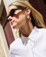 Model wearing fox embroidered and beaded earrings against a downtown background