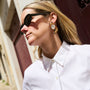 Model wearing fox embroidered and beaded earrings against a downtown background