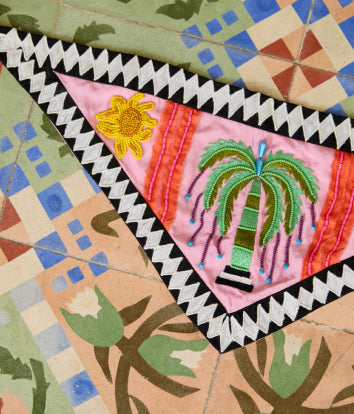 Colorful quilt with geometric patterns and embroidered elements