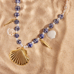 Blue and White Beads and Shell Charms and Fish Charms Pendant Charm Necklace Styled in Sand