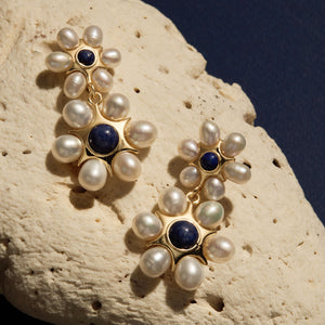 Blue Stone, Gold, and Pearl Drop Earrings Staged on Coral 