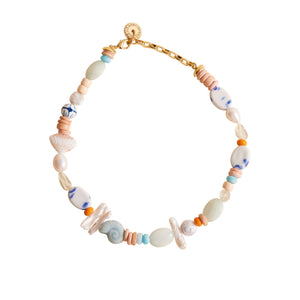 Shell, Pearl, and Bead Strand Collar Necklace on Flat White Background