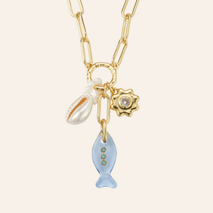 Fish, Shell, and Flower Charm Pendant Necklace on Tan Background