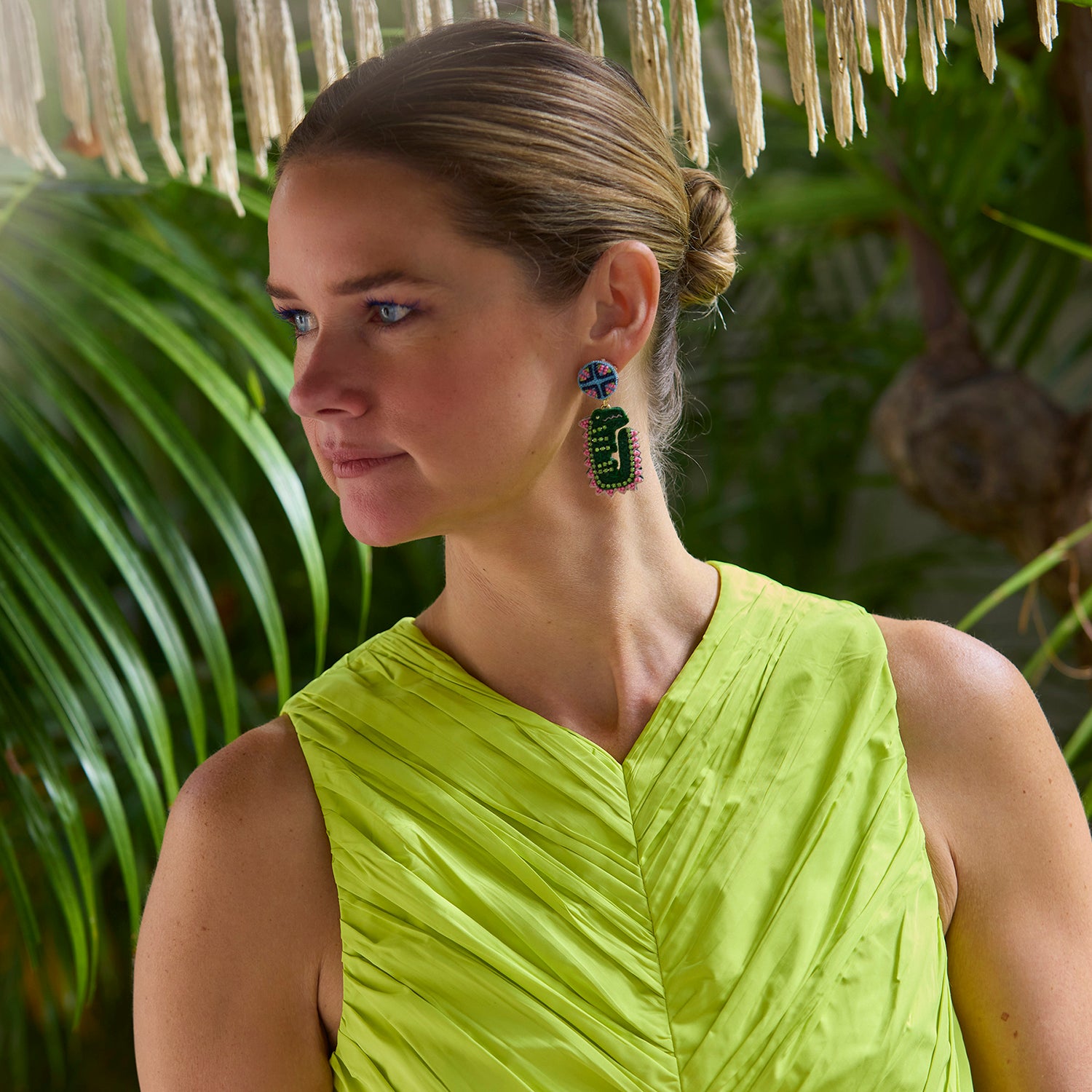 Model Wearing Leslie Earrings against dark background in yellow dress. 