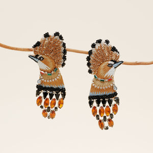 Gold, Black, and Multi Colored Crystal and Bead Bird Earrings Staged on Branch with Tan Background