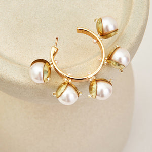 Gold and Pearl Hoop Earrings Staged on Stone