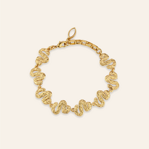 Gold Chain Bracelet on Tan Background