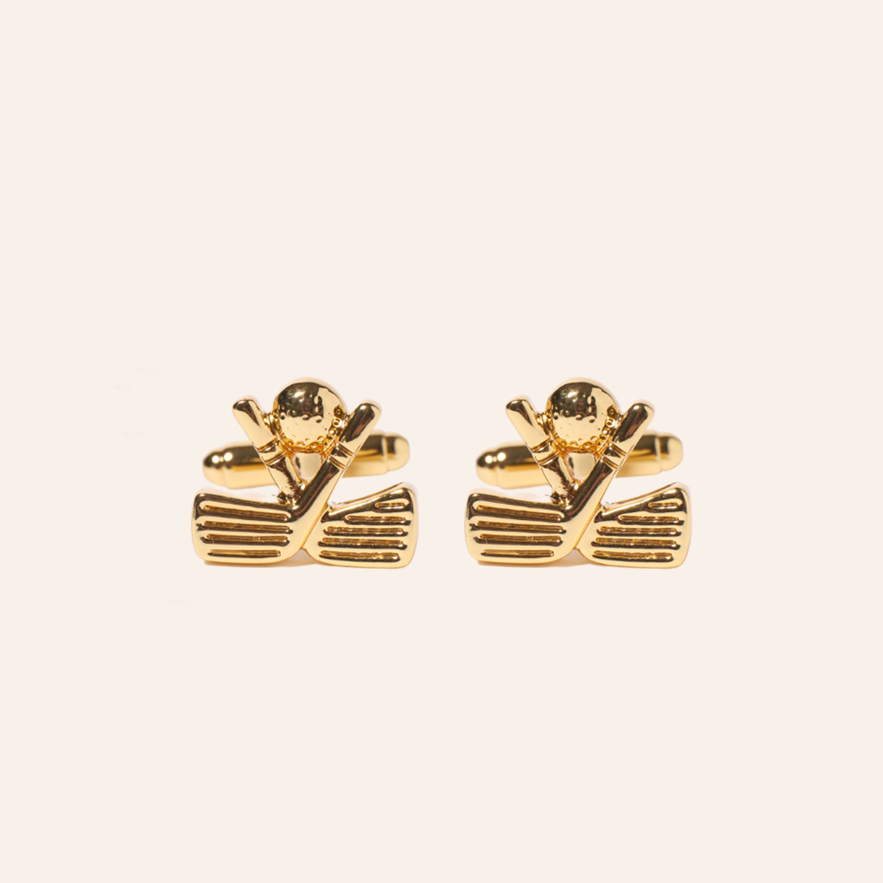 Gold Crossed Golf Clubs and Ball Cuff Links on Tan Background