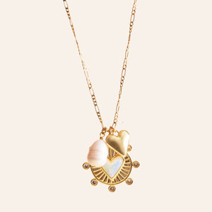 Gold, Pearl, and Crystal Charm Pendant Necklace on Cream Background