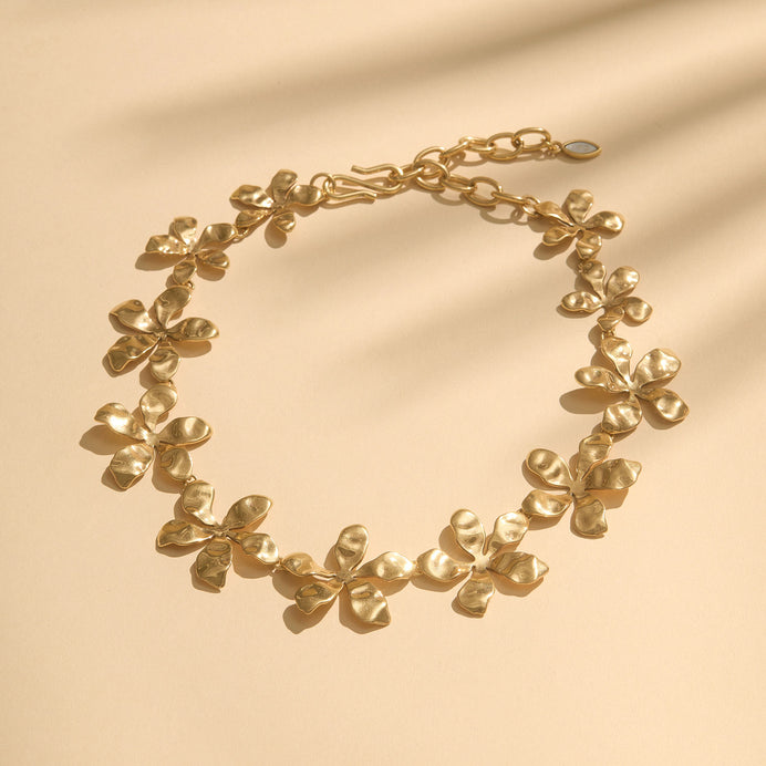 Gold Flower Collar on Flat Cream Background with Shadows