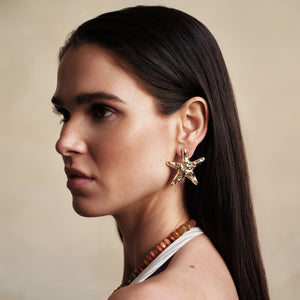 Hammered Gold Star Fish Stud Earrings Styled on Model