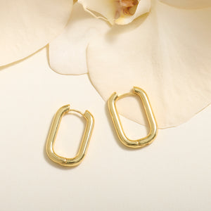 Gold Hoop Earrings Staged on Flower with Cream Background