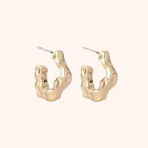 Gold Hoop Earrings on Tan Background