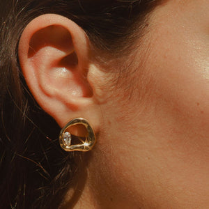 Gold Stud Earrings with Crystal Accent Staged on Stone Styled on Model's Ear