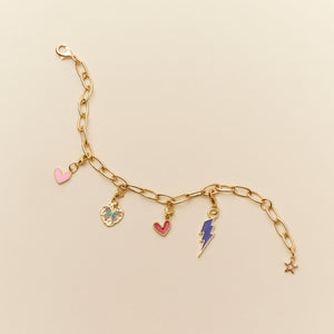 Gold Chain Bracelet with Heart Charms, Butterfly Charm, and Lightning Bolt Charm on Tan Background