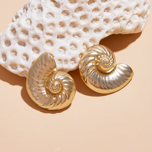Gold Shell Stud Earrings Styled with Coral on Cream Background