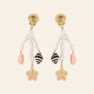 Gold, Freshwater Pearl, and Shell Charm Drop Earrings on Tan Background