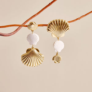 Gold and White Shells Drop Earrings Styled on a Branch with Cream Background