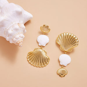 Gold and White Shells Drop Earrings Styled with Natural Shell on Cream Background