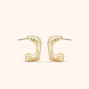 Gold Stud Earrings on Tan Background