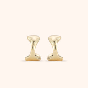 Gold Stud Earrings on Tan Background