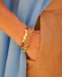 Wavy Gold Cuff Bracelet On Wrist with Gold Chain Bracelet