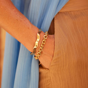 Wavy Gold Cuff Bracelet On Wrist with Gold Chain Bracelet