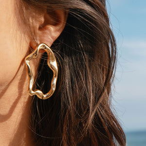 Gold Wavy Organic Stud Earrings on Model's Ear