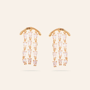 Gold and Clear Crystal Dangle Earrings on Cream Background