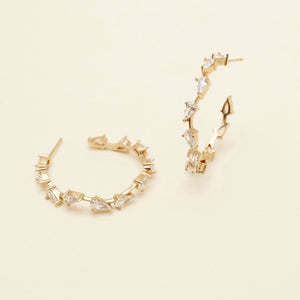 Gold and Crystal Hoop Earrings on Cream Background