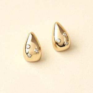 Gold and Clear Crystal Stud Earrings on Tan Background