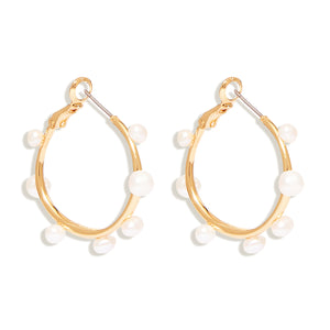 Gold and Multi-Sized White Pearl Hoop Earrings On Flat White Background