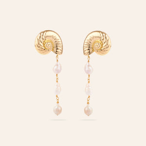 Gold Shell and Pearl Dangle Earrings on Cream Background