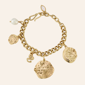 Gold and Pearl Charm Bracelet on Tan Background