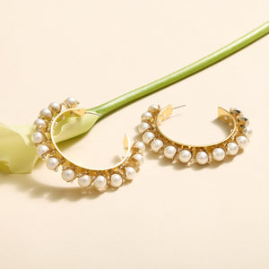 Gold and Pearl Hoops Staged with Flower on Tan Background