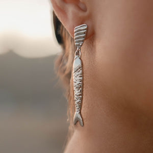 Gold and Silver Fish Drop Earrings on Model's Ear