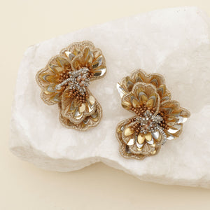 Gold and Silver Beaded and Embroidered Flower Stud Earrings Staged on Stone with Tan Background