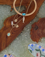 Gold necklaces with blue stones on a wooden surface