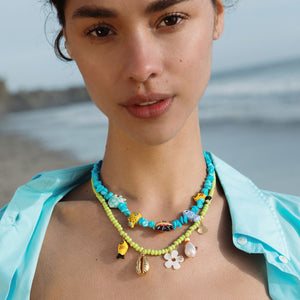 Green Beaded Strand Necklace with Fish, Shell, Flower, and Pearl Charms Styled on Model