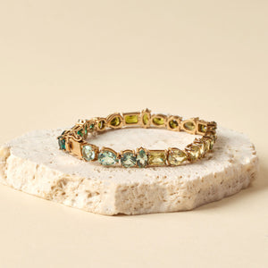 Green Crystal Tennis Bracelet Staged on Stone with Tan Background