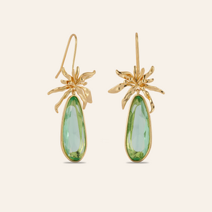 Green Crystal and Gold Flower Drop Earrings on Tan Background