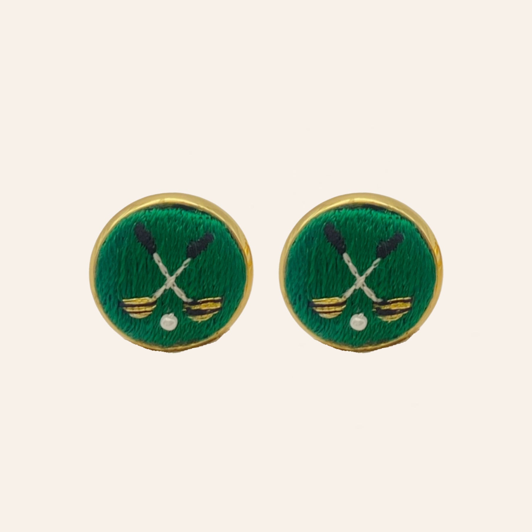 Green golf ball and club embroidered cuff links on tan background