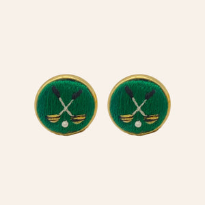 Green golf ball and club embroidered cuff links on tan background