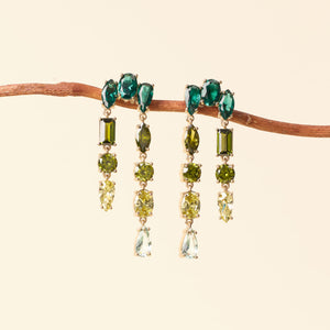 Green Crystal Drop Earrings Staged on Branch on Tan Background