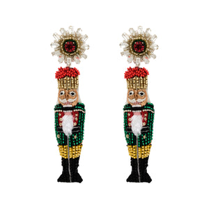 Green, Red, and Gold Beaded Nutcracker Drop Earrings on Flat White Background