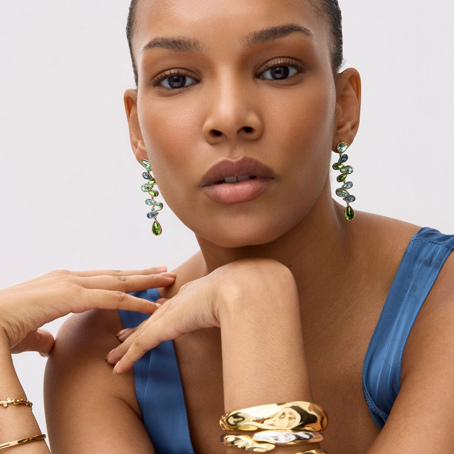Green and Blue Crystal Statement Earrings  Styled on Model with Various Gold Bracelets