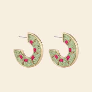 Pink and Green Embroidered Hoop Earrings on Tan Background