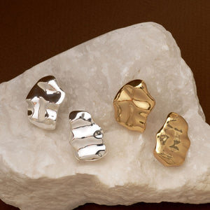 Hammered Gold Organic Stud Earrings Staged on Stone with Hammered Silver Organic Stud Earrings