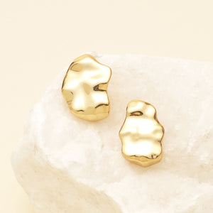 Hammered Gold Stud Earrings Staged on Rock with Cream Background