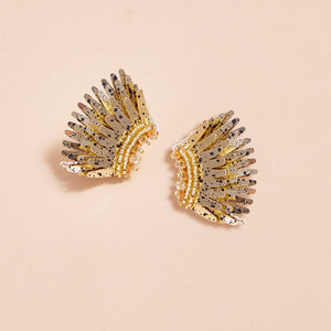 Gold Sequin and Bead Wing Stud Earrings with Black Splatter Paint on Tan Background